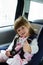 Little cute girl sitting in the car in child safety seat