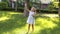 A little cute girl in a summer light dress playing with soap bubbles in the Park