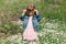 Little cute girl in sunglasses on the field with daisies. Sunny day outside