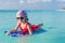 Little cute girl swimming on a surfboard in the