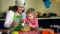 Little cute helper daughter help beautiful mother with cake baking in kitchen