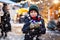 Little cute kid boy drinking hot children punch or chocolate on German Christmas market. Happy child on traditional