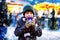 Little cute kid boy drinking hot children punch or chocolate on German Christmas market. Happy child on traditional