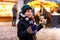 Little cute kid boy eating German sausage and drinking hot children punch on Christmas market. Happy child on