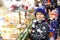 Little cute kid boy near sweet stand with gingerbread and nuts. Happy child on Christmas market in Germany. Traditional