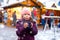 Little cute kid girl with cup of steaming hot chocolate or children punch. Happy child on Christmas market in Germany