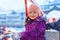Little cute kid girl having fun on ferris wheel on traditional German Christmas market during strong snowfall. Happy
