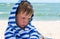 Little cute kid hurt and pouted, disappointed. Beautiful little kid with atopic dermatitis on the background of the sea,