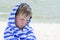 Little cute kid hurt and pouted, disappointed. Beautiful little kid with atopic dermatitis on the background of the sea,