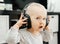 Little cute playful child in big black wireless bluetooth headphones listens to music.