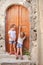 Little cute sisters near old door in Greek village