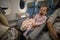 Little cute sleepy toddler sitting in an airplane seat and yawning tiredly