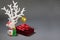 Little cute snowman, white tree, red gift box with ribbon and golden ball.