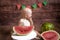 Little cute toddler with blond hair sits in basket with watermelon on a dark wooden background. Children and fruits.