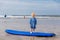 Little cute toddler girl at the Ballybunion surfer beach, having fun on surfboard for the first time, west coast of