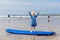 Little cute toddler girl at the Ballybunion surfer beach, having fun on surfboard for the first time, west coast of