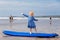 Little cute toddler girl at the Ballybunion surfer beach, having fun on surfboard for the first time, west coast of