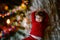 Little cute toddler girl lies under Christmas tree and dreaming of Santa at home, indoors. Traditional Christian