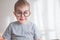 Little cute toddler preschooler boy in glasses with book looking straight at camera. Back to school concept