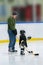 Little cute white hockey girl with dad on ice play hockey in full equipment