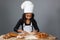 Little dark-skinned girl rolls the dough.