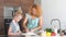 Little daughter helping mother baking in kitchen, family and cooking