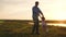 Little daughter plays with dad on the beach in the sun. daddy is spinning for the hands of a happy child in the rays of