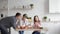 A little daughter treats her dad with a fresh cucumber while cooking a salad with the whole family.Mom, dad and daughter