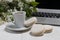 Little delicate elegant bouquet of spring flowers and a teacup on white wooden table, morning breakfast