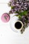 Little delicate elegant bouquet of spring flowers and a teacup on white wooden table, morning breakfast