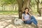 Little dog and its owner resting in the shade