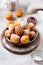 Little Donuts. Homemade curd fried cookies in deep fat and sprinkled with icing sugar in a vintage plate on a light background.