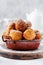 Little Donuts. Homemade curd fried cookies in deep fat and sprinkled with icing sugar in a vintage plate on a light background.