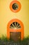 The little door and round window in a yellow wall