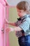 Little dreaming boy opens pink door