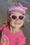 Little dreamy girl in pink in sunglasses reflecting the sun