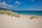 Little dunes with plants and Atlantic ocean in beach of Cadiz