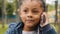Little ethnic girl talking on mobile phone outdoors portrait funny multiracial child answer telephone call small African