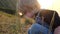 Little fair-haired boy. Kid plays on green grass at sunset.