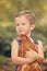 Little farm boy holding red chicken