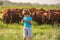 Little farmer holding tablet in cows farm.