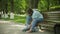 Little fat girl sitting on a bench listening to music clothes roller skates in the park