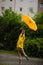 Little fellow in a bright yellow raincoat flies over the earth with an umbrella in hand.