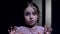 Little female child scared, looking at camera, afraid of darkness, ghosts phobia