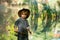 Little fisherman on a background of beautiful nature. A boy with a fishing rod and a cowboy hat. Happy fishing holidays