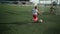 Little football player is kicking ball into goal