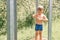 Little four year old kid boy fun pours himself with cold water from a watering can from a outdoor shower in the summer during the