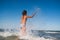 Little funny active girl splashing in noisy sea