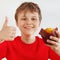 Little funny boy in a red shirt recommends muffin on white background