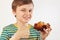 Little funny boy in a striped shirt recommends sweet apple cake on white background